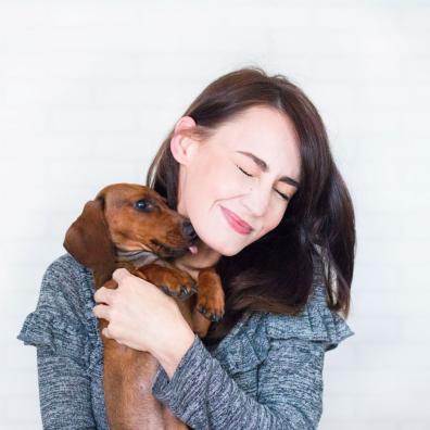 Woman In Grey Top Hugging Brown Dachshund