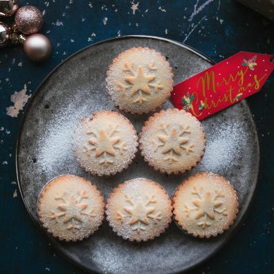 mince pies on a plate with a red merry Christmas tag